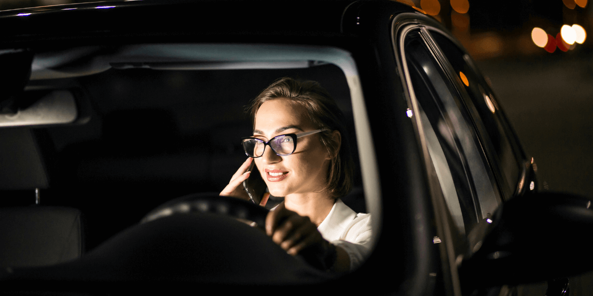 Lady wearing glasses sitting in a car.