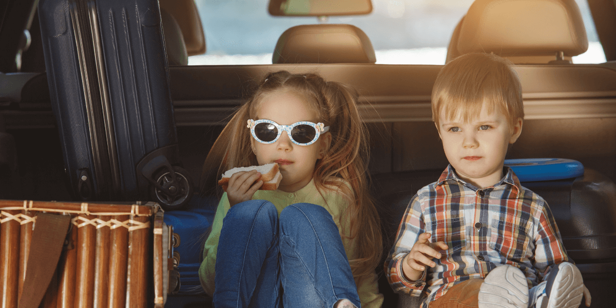 Children sitting safely in the back seat of a car, enjoying the ride.