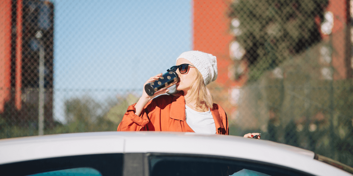 Lady outside the car mirror, drinking water